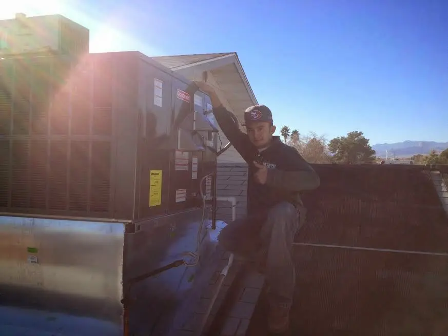 HVAC technician performing AC Tune-Up on a rooftop unit in Huber Heights